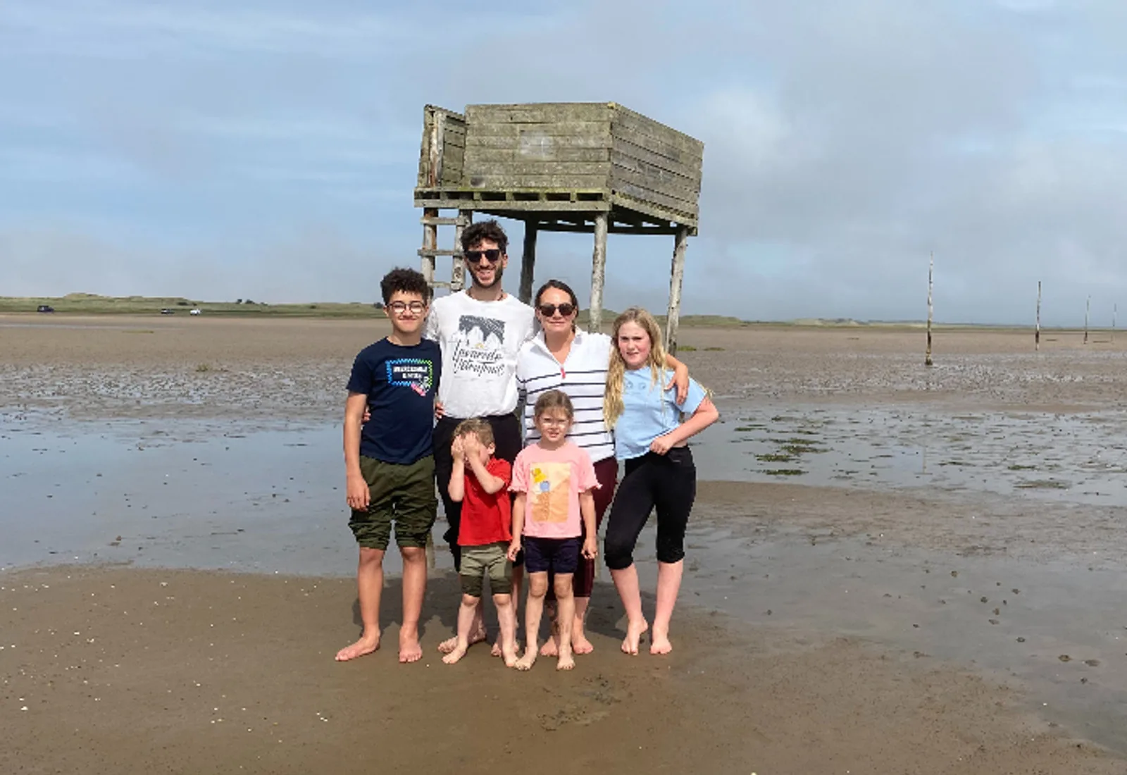 A family walking together across the sands towards Holy Island